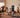 A multi-generational family performing various exercises together in a living room using a smart home gym mirror.