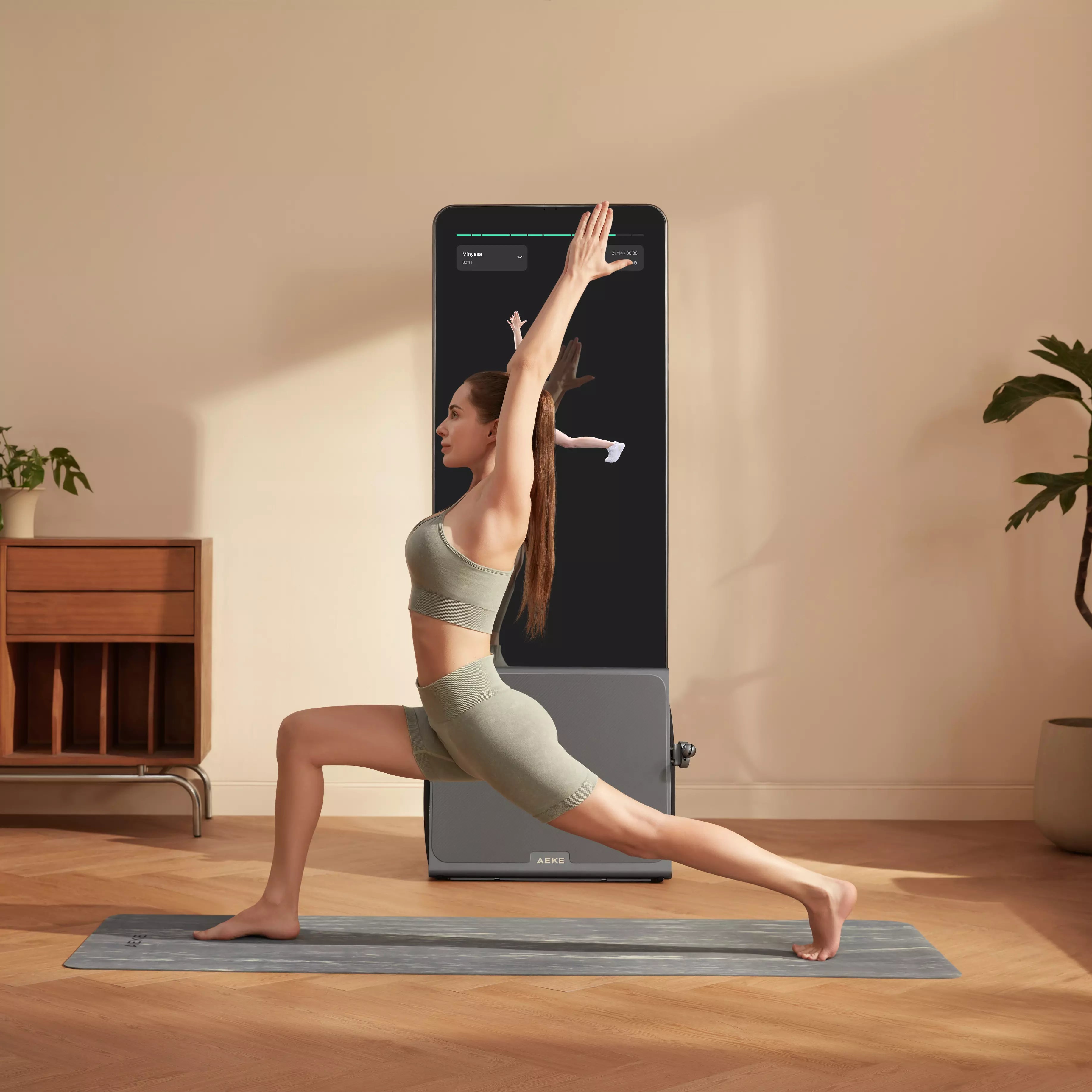A woman performing a yoga lunge while following an instructor on a smart fitness mirror.