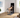 Person doing a dumbbell workout on a foldable weight bench in front of a smart mirror.