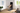 Person doing a dumbbell workout on a foldable weight bench in front of a smart mirror.