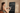 Woman adjusting workout settings on a smart mirror touchscreen while holding a phone.