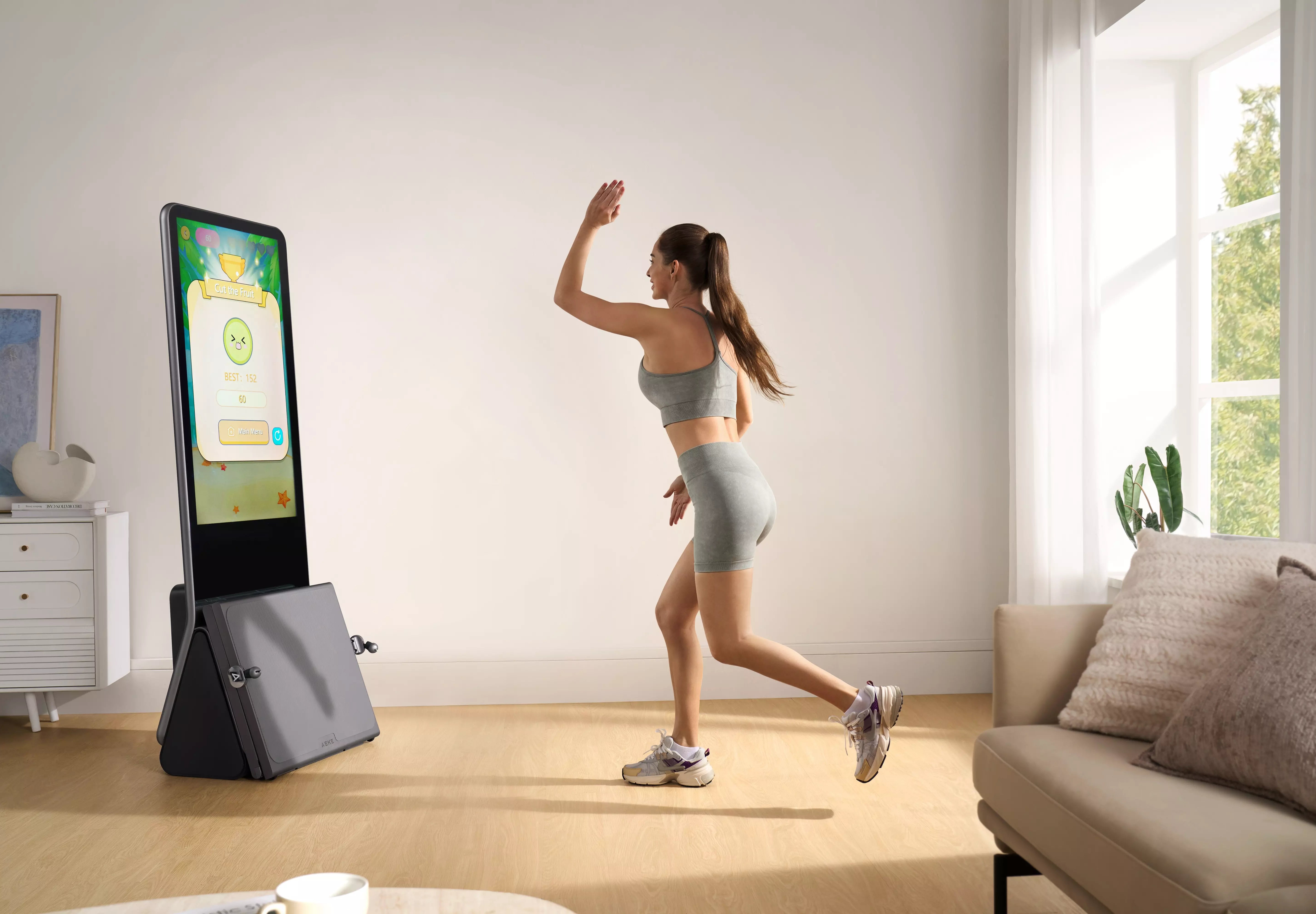 Woman playing fitness game on AEKE smart workout mirror in bright living room
