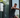 Man performing a standing cable chest press on a digital resistance training machine beside large windows