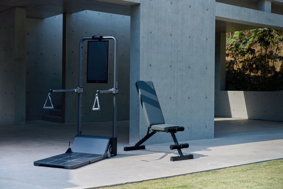 Digital body-analysis scale with a foot platform, hand grips, and a display in a bright room