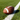An American football resting on a lush green field next to a crisp white yard line.