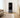 A sleek, smart fitness mirror in a modern living room setting, perfect for a professional and tidy home workout.