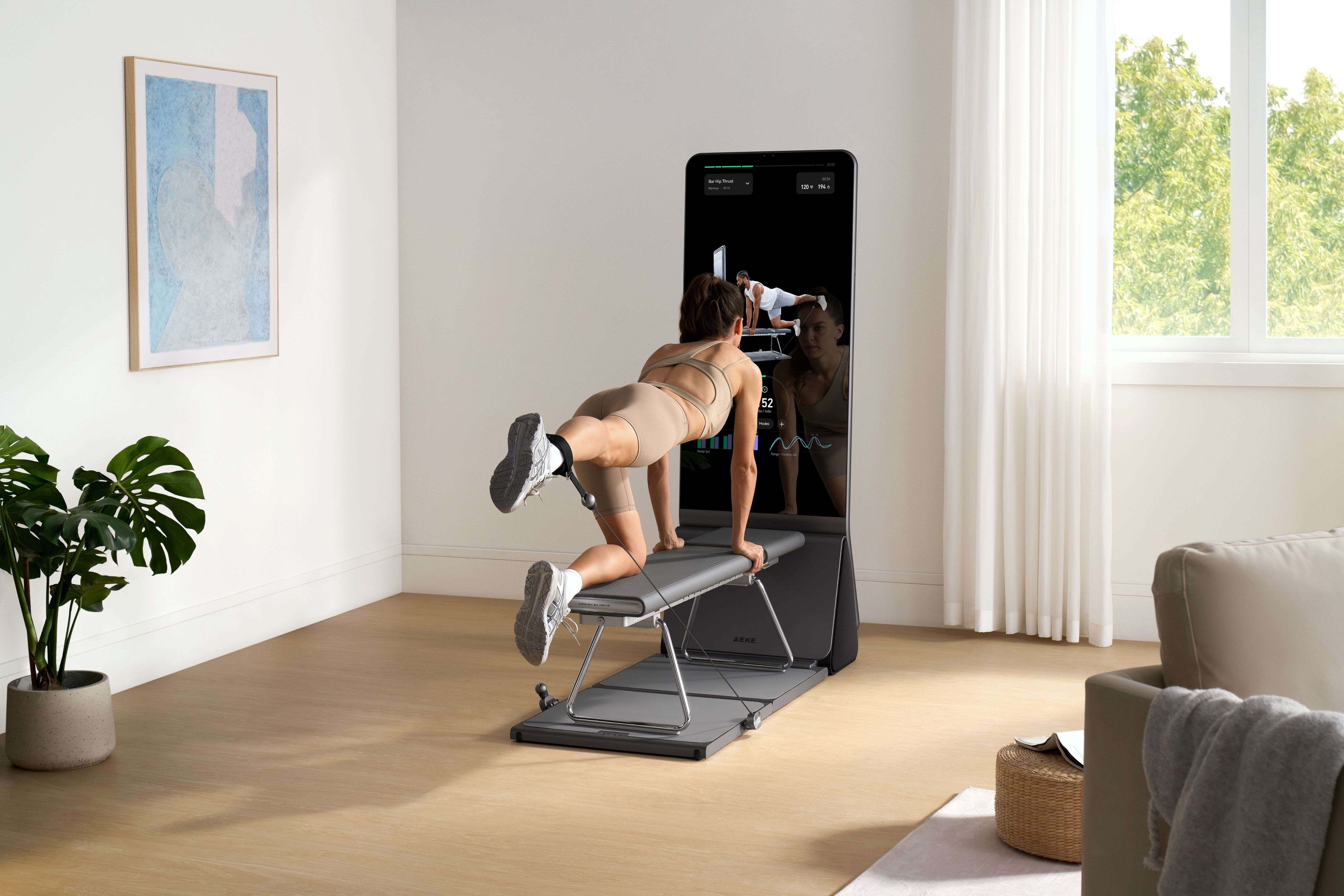 A woman exercises on a bench with a mirrored smart home gym in a modern room.