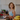 Woman in a kitchen holding a bowl of berries, with bananas and a fruit bowl in the foreground.